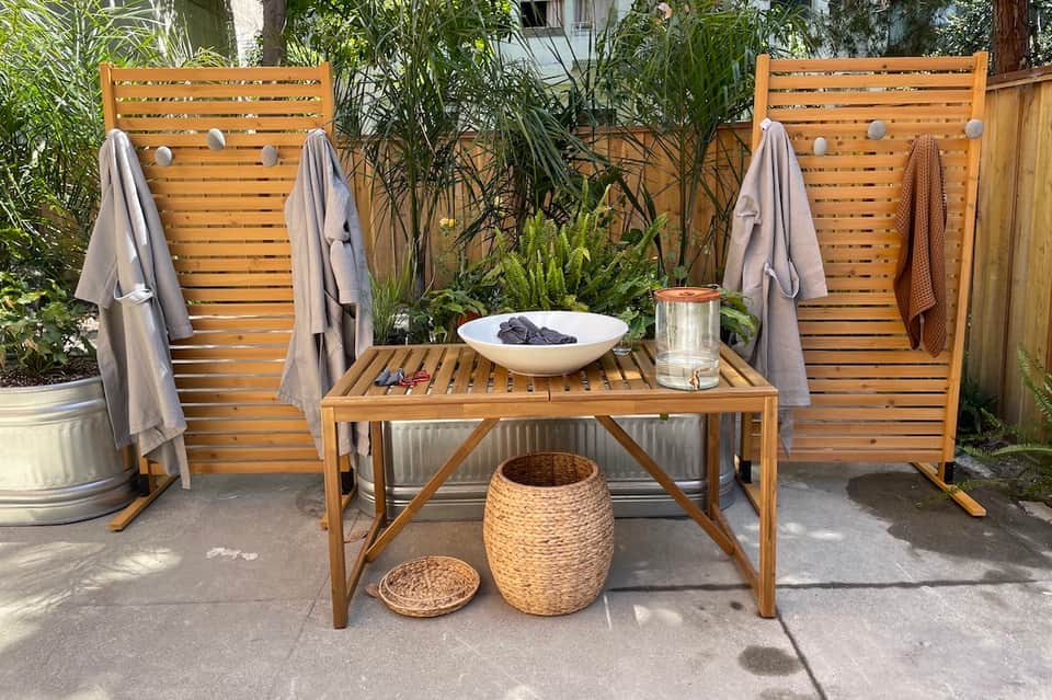Wooden lounge chairs and table with towels in a tropical garden patio setting