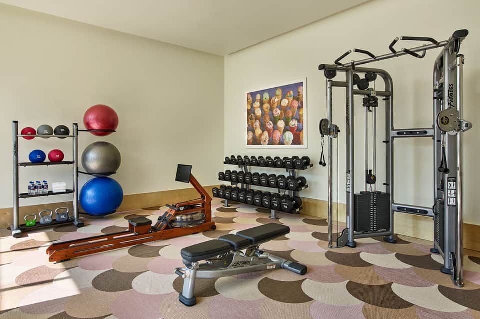 Home gym with exercise equipment, dumbbells, stability balls, and strength training machines