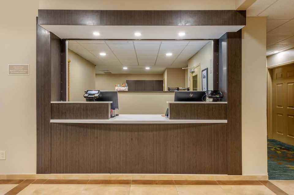Hotel front desk with dual reception areas, dark wood paneling, and modern amenities