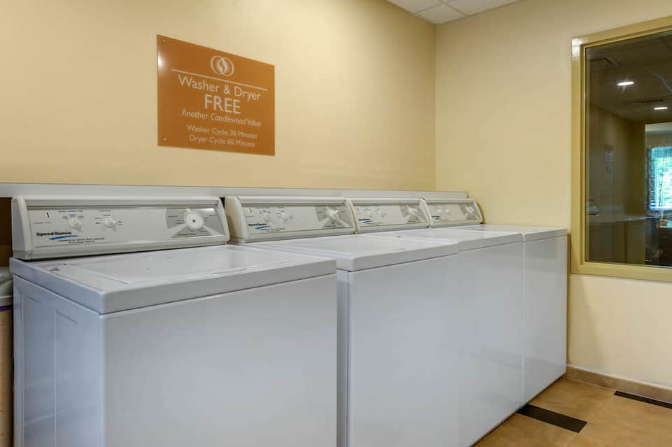 Laundry facility with white washers and dryers, orange sign advertising free service