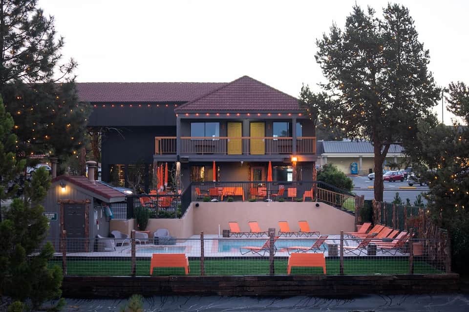 Lakeside resort with orange chair seating, evening lights, and multi-story lodge building