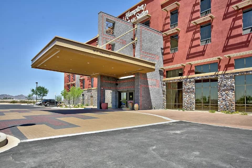 Historic hotel building exterior with red brick, stone accents, and modern porte-cochere entrance