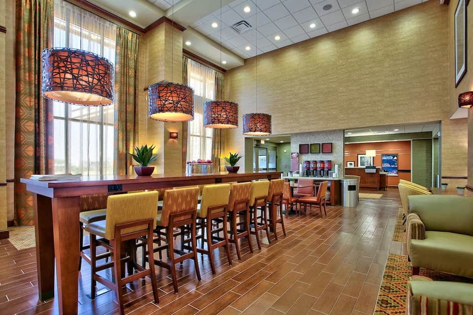 Hotel lobby bar and lounge with decorative pendant lights, wood accents, and comfortable seating areas
