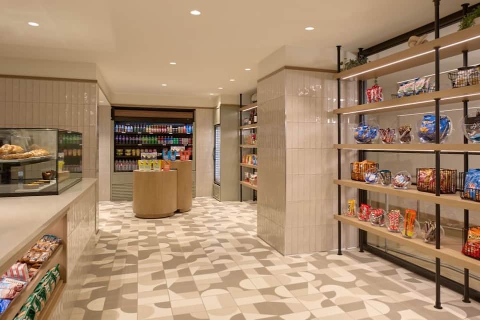 Modern market or café with shelving, refrigerated displays, and geometric floor pattern