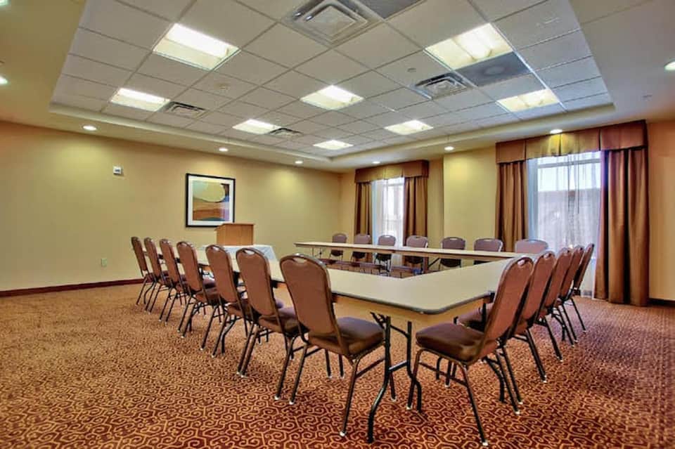 Conference room with U-shaped table arrangement and brown upholstered chairs
