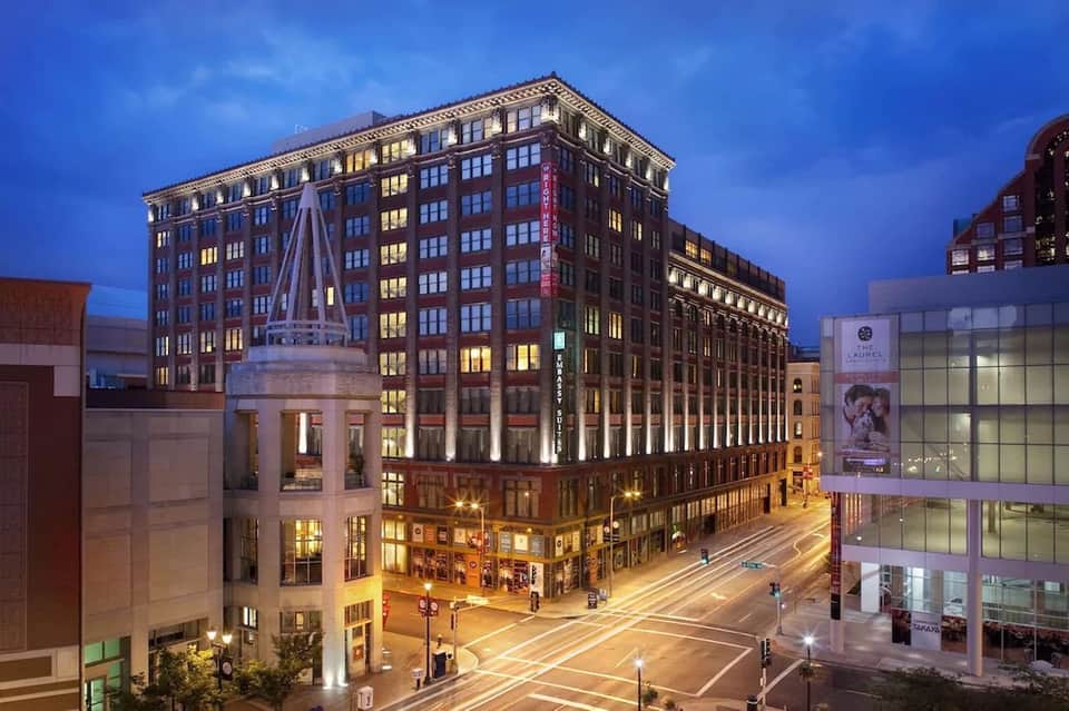 Historic brick hotel building illuminated at dusk in urban downtown setting
