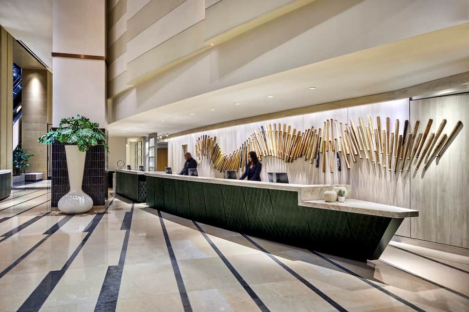 Modern hotel lobby with curved reception desk and gold decorative wall panels