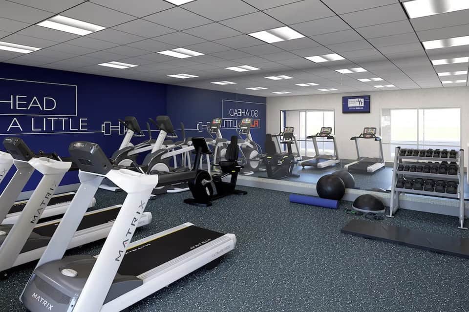 Modern fitness center with treadmills, exercise bikes, and strength training equipment