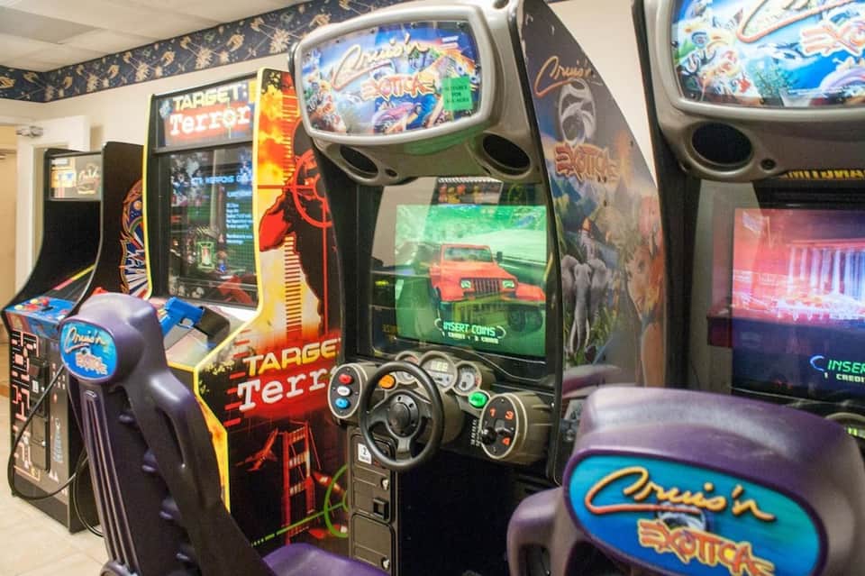 Arcade game room with vintage video game cabinets including Target Terror and driving games