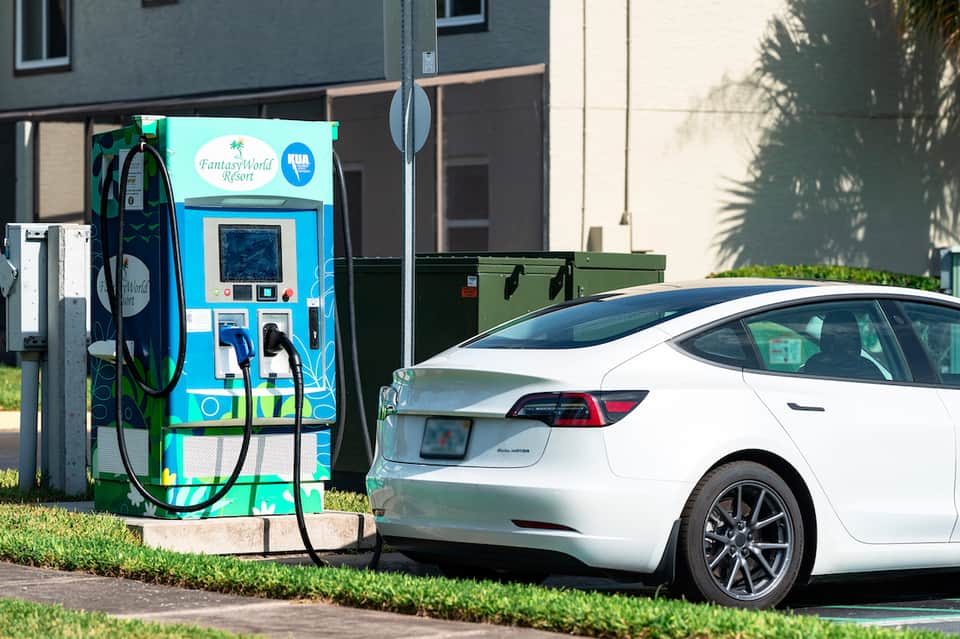 White electric vehicle charging at FantasyWorld Resort branded charging station