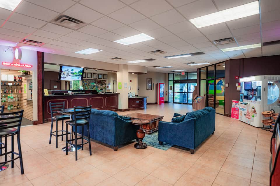 Hotel lobby with bar, comfortable seating areas, blue couches, and welcoming reception desk