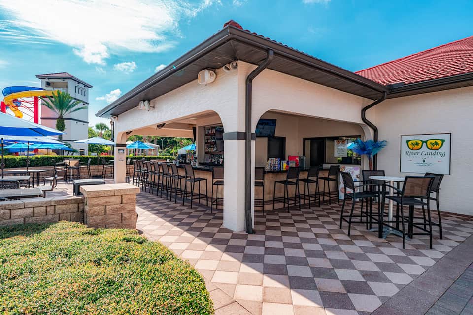 Covered outdoor bar and patio area with checkered flooring and casual seating