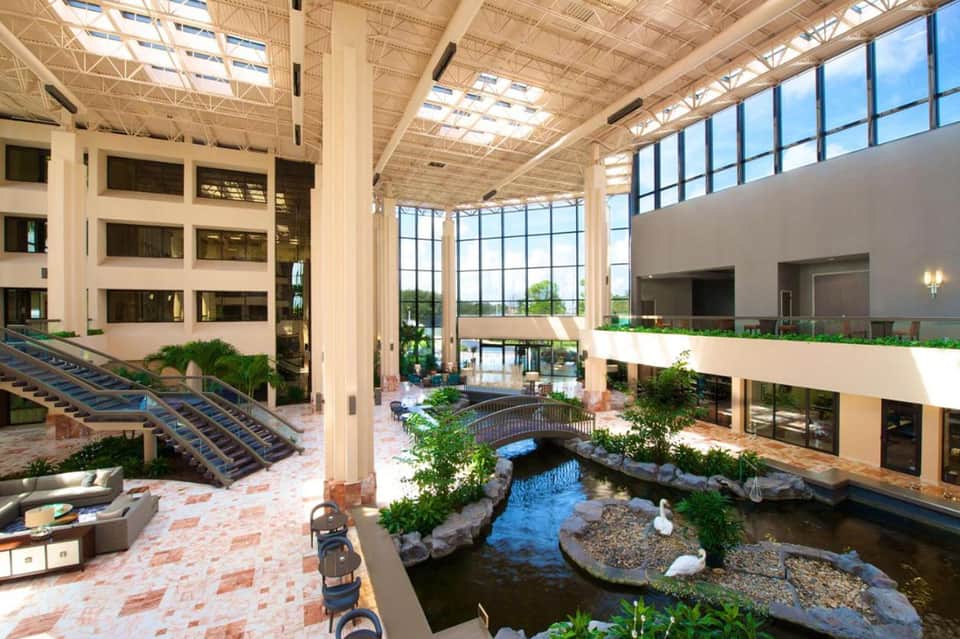 Indoor atrium with high ceiling, skylights, indoor stream, and multi-level balconies