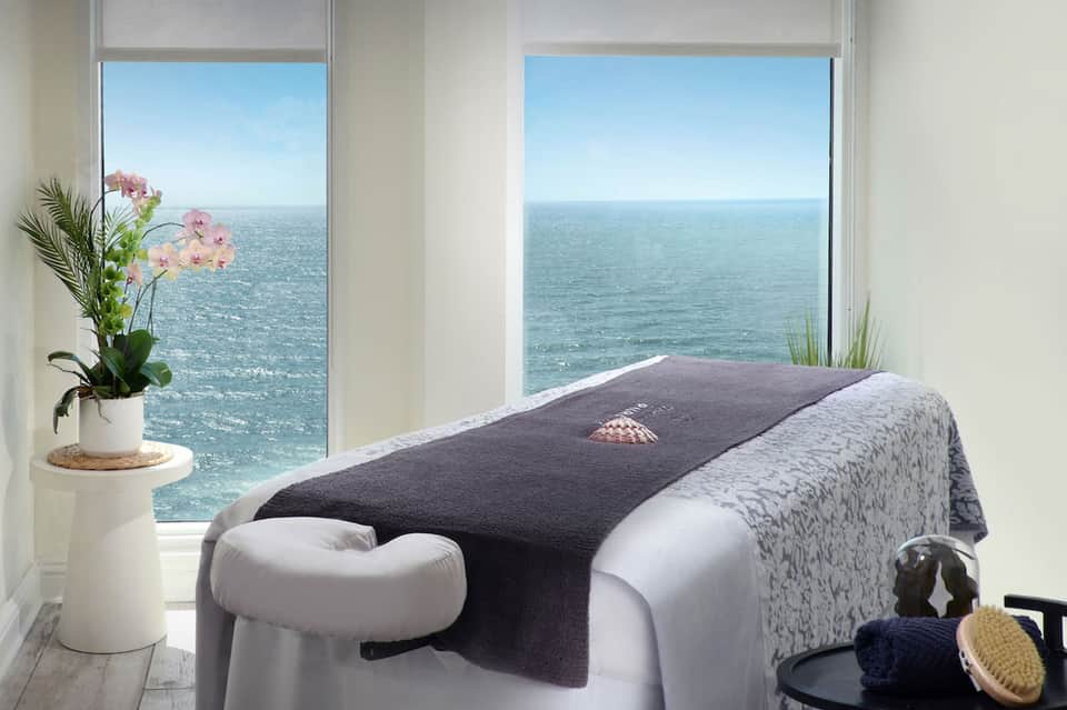 Oceanview spa massage table with sea vista through floor-to-ceiling windows