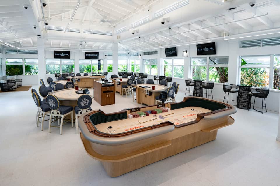 Modern recreational game room with air hockey, billiards tables, and lounge seating with ocean views