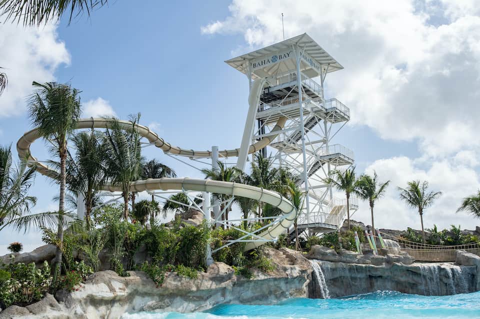 Water park slide tower with turquoise pool and palm trees at Bahia Bay
