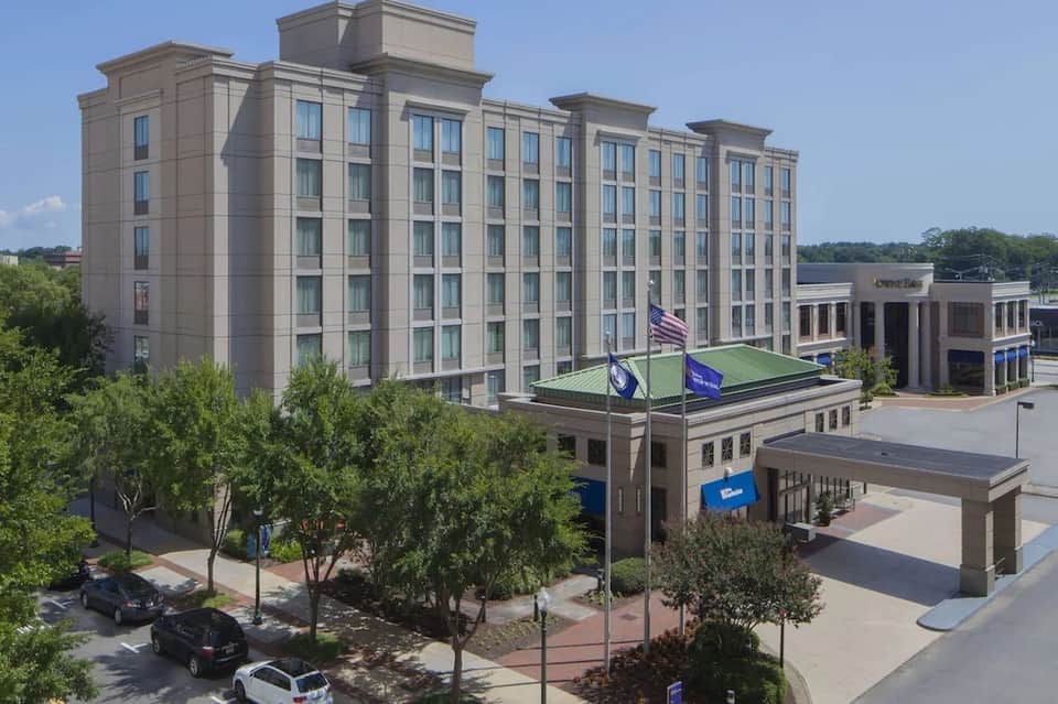 Modern beige hotel building with multiple stories and ground-floor entrance with blue branding