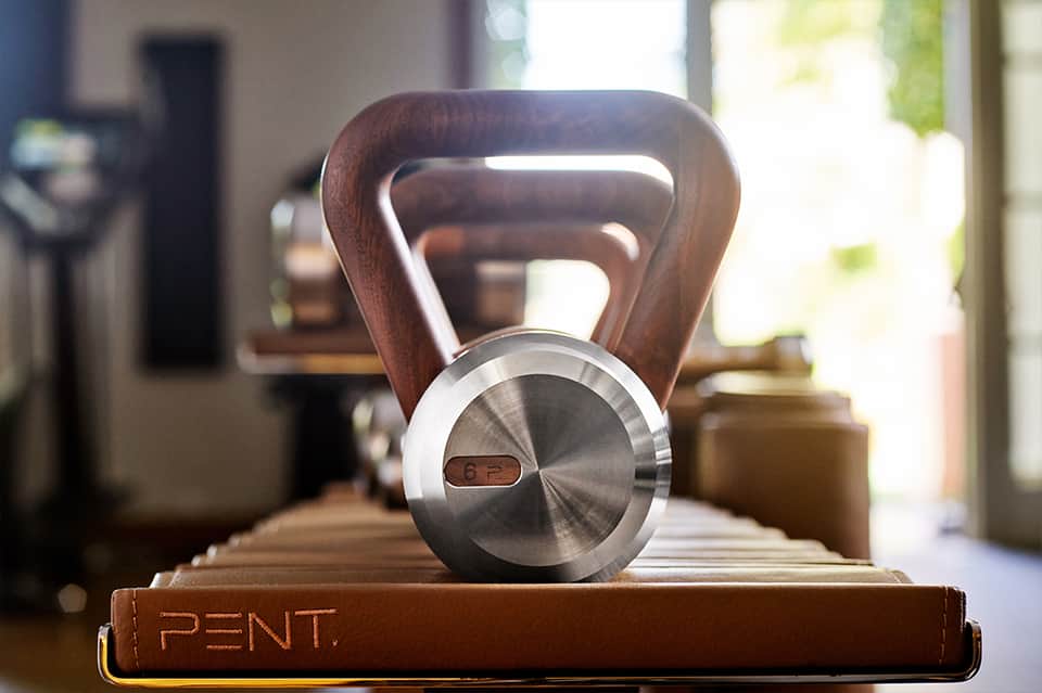 Wooden kettlebell with metal details on display stand indoors