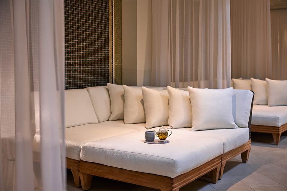 Luxury spa relaxation lounge with cream daybed and sheer curtains