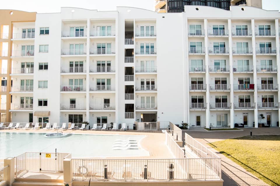 Modern white beachfront resort building with pool and sandy beach access