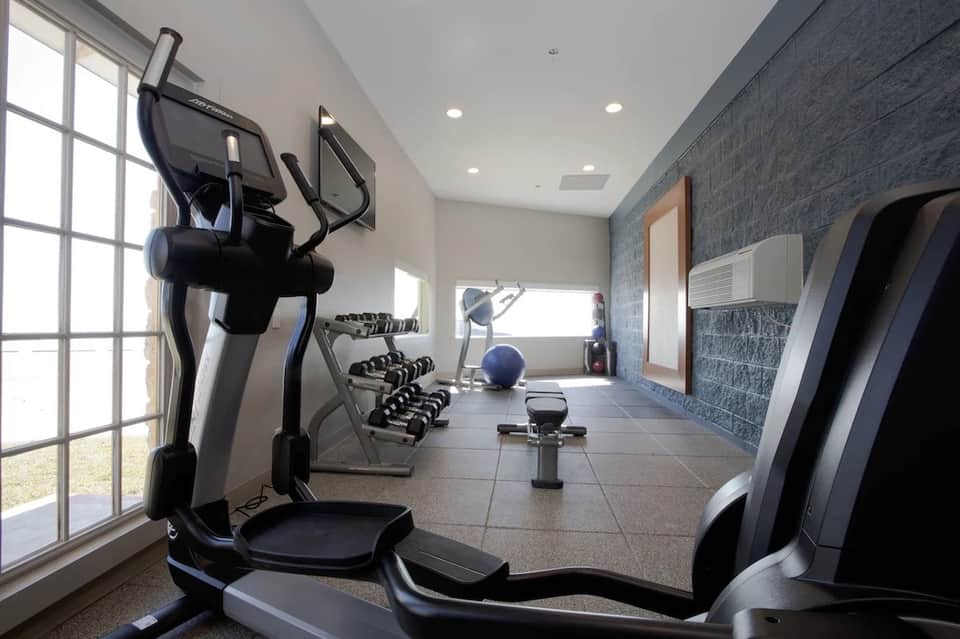 Modern fitness center with elliptical machines and dumbbells