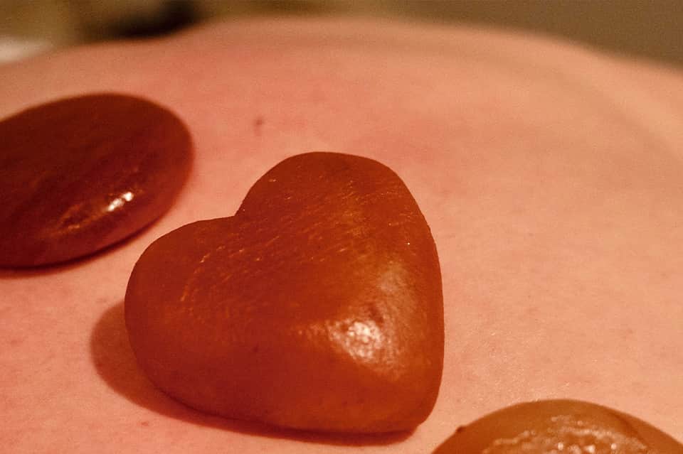 Close-up of red heart-shaped objects on coral pink sand surface