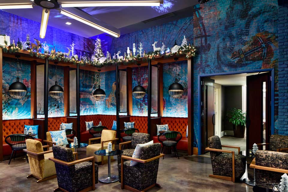 Elegant lounge area with blue brick walls, holiday decorations, and upholstered seating