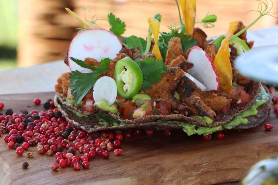 Gourmet appetizer with roasted meat, fresh vegetables, radish, and red currants on wooden board