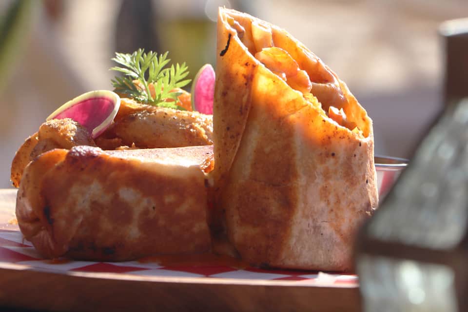Gourmet plated dish with crispy pastry, sauce, and microgreens garnish on white plate
