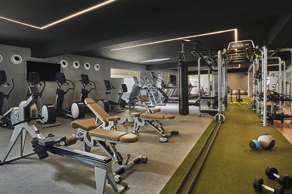 Modern fitness center with exercise equipment, cardio machines, and functional training area
