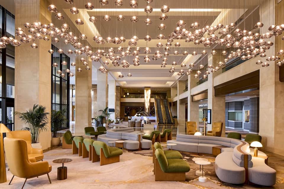 Luxurious hotel lobby with copper pendant lights, marble columns, and contemporary seating