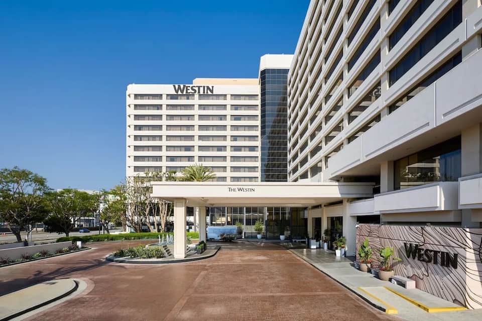 Modern hotel entrance with Westin signage, multi-story white building, and curved driveway