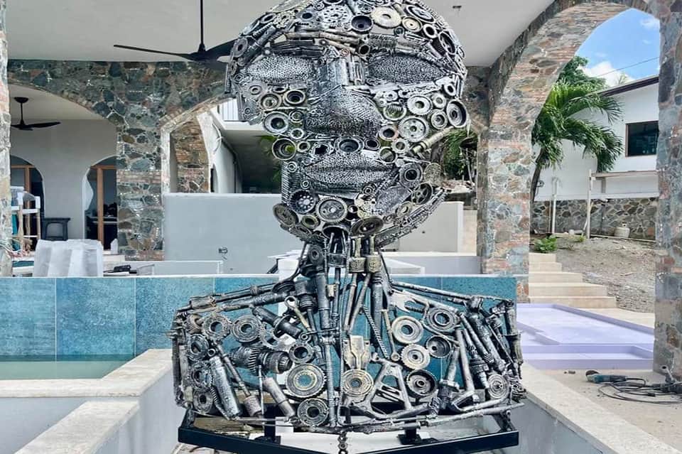 Metal sculpture of a human head and shoulders made from mechanical parts and gears