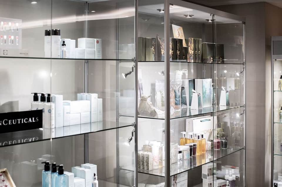 Spa retail display with glass shelving and metal frames showcasing skincare and beauty products