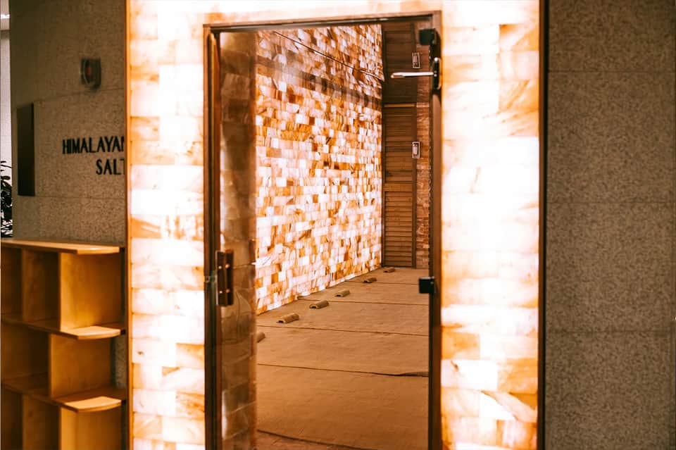 Himalayan salt therapy room entrance with illuminated orange salt brick walls and wooden door