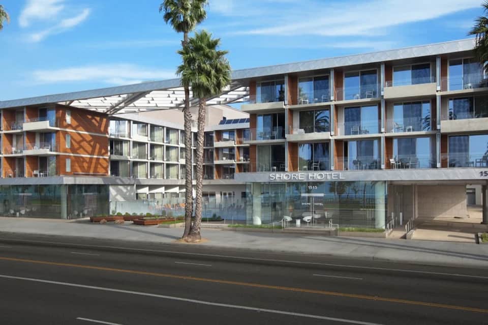 Modern Shore Hotel exterior with multi-story building, palm trees, and street-level entrance
