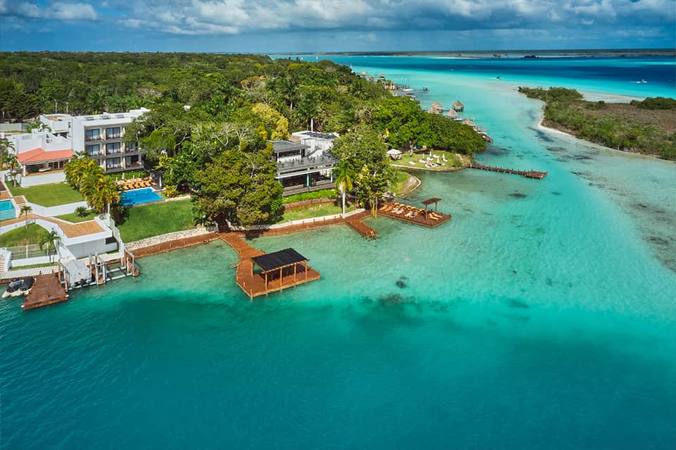 Aerial view of tropical resort with turquoise lagoon, white sandy beach, and lush vegetation