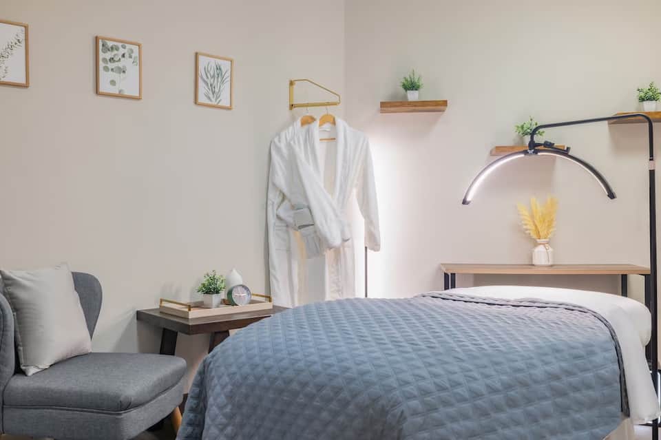 Minimalist bedroom with metal frame bed, wooden nightstand, and botanical wall art