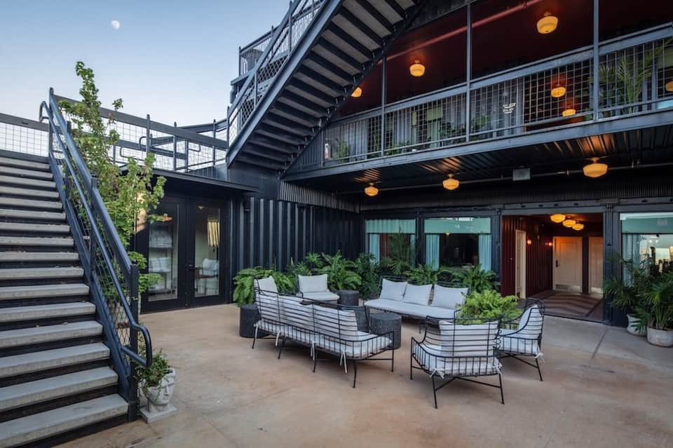Industrial outdoor courtyard with modern seating and hanging pendant lights