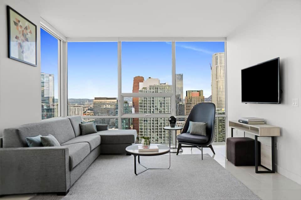 High-rise hotel suite living room with floor-to-ceiling windows overlooking city skyline