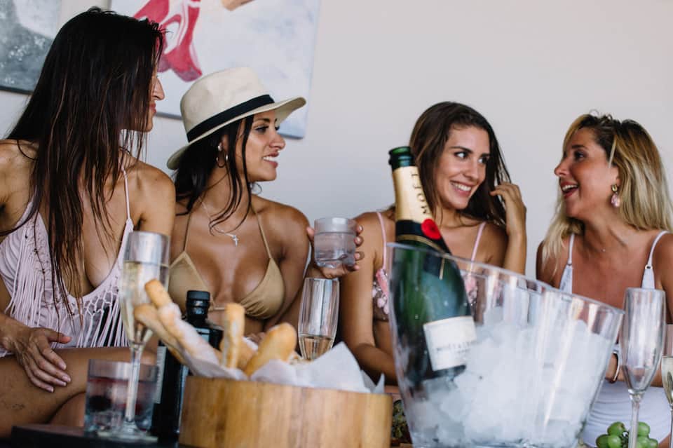 Group of women celebrating with champagne and appetizers at a resort gathering