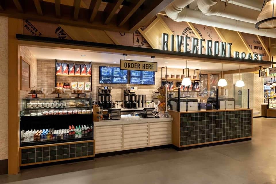 Riverfront Roast coffee shop kiosk with menu boards and service counter in modern interior