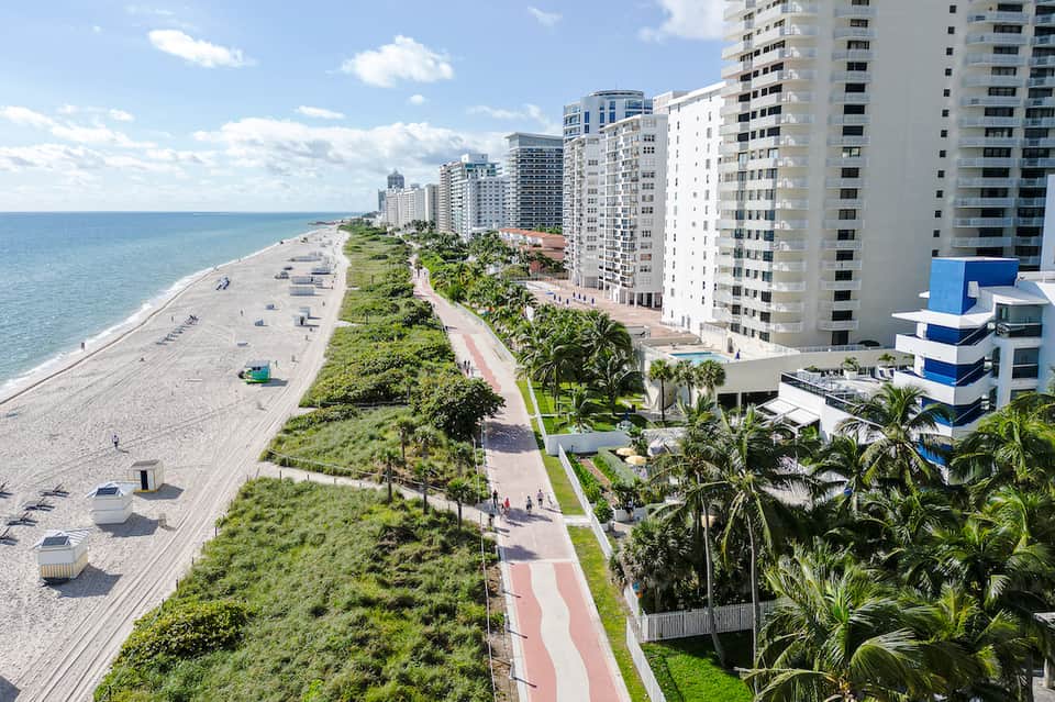 Beachfront Miami resort with high-rise buildings, palm trees, and sandy beach