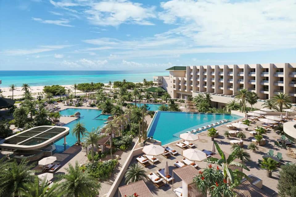 All-inclusive beachfront resort with multiple pools, palm trees, and turquoise ocean