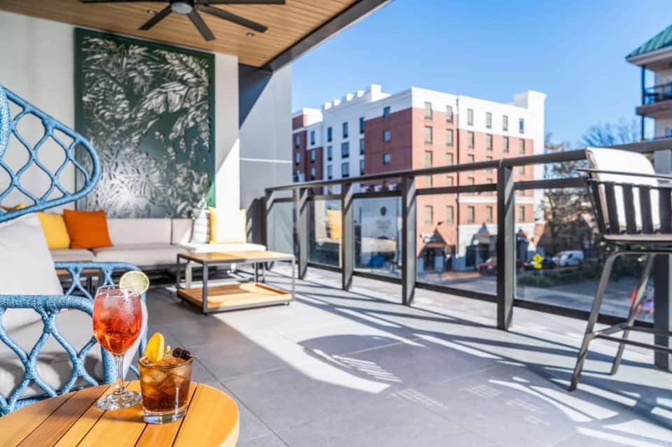 Rooftop terrace lounge with sofa, cocktails, city views, and modern furniture