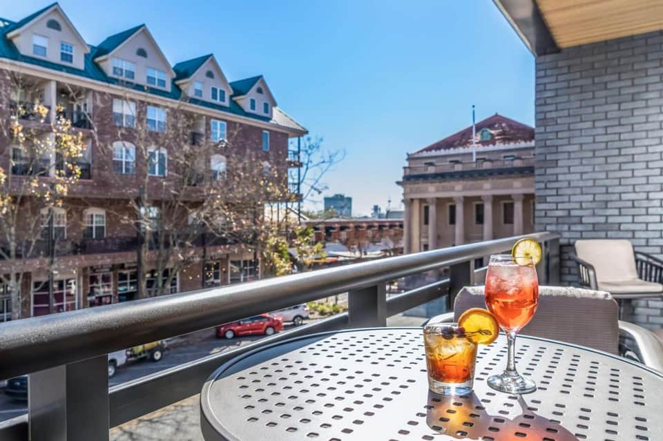 Rooftop bar with cocktails overlooking historic brick buildings and city architecture