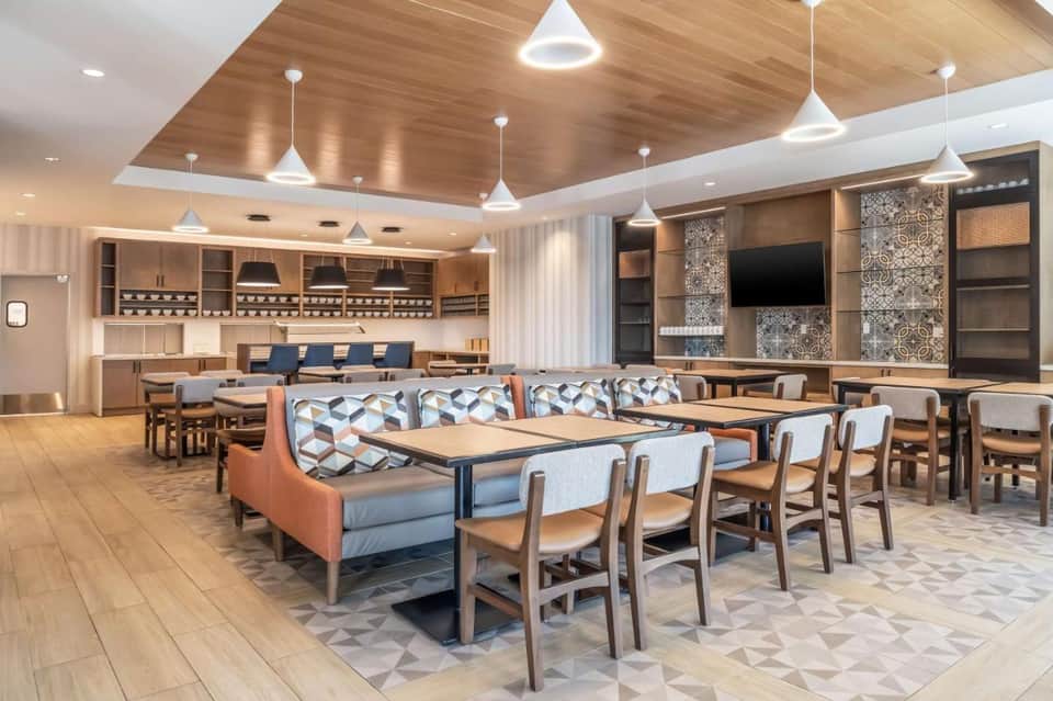 Contemporary hotel lobby lounge with geometric seating, wood accents, and modern lighting