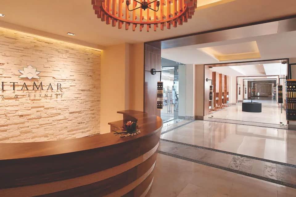 Luxury spa reception desk with wooden signage and modern chandelier lighting