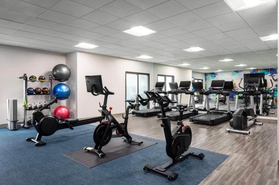 Fitness center with exercise bikes, treadmills, colorful exercise balls, and modern equipment