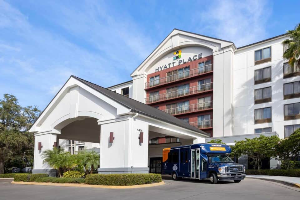 Hyatt Place hotel exterior with white portico entrance and multi-story residential building
